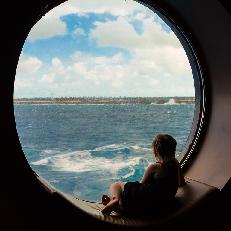 Katelyn sitting in one of the porthole windows, looking at Castaway Cay. (243.41 KB)