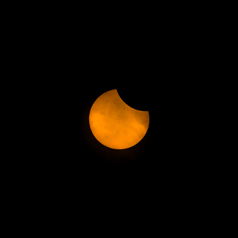 I caught an early part of the eclipse (20 minutes after C1) through the clouds along with some sunspots. (32.52 KB)