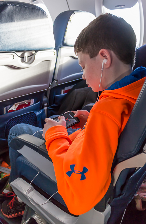 Andrew enjoying games on his iPhone on the plane. (205.07 KB)